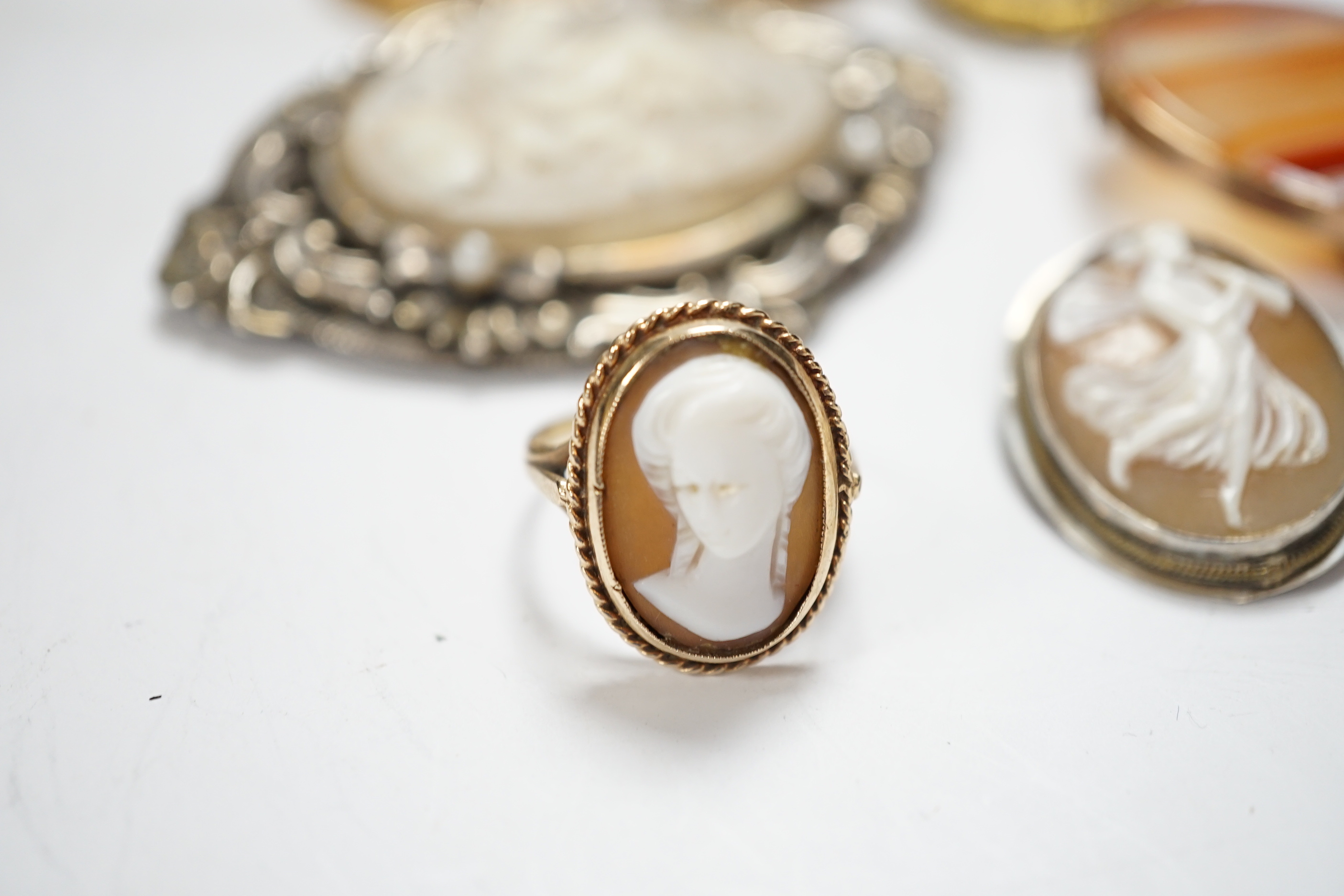 Two modern 9ct gold mounted oval cameo shell brooches, a 9ct gold and cameo shell set ring, three other cameo shell set brooches and a 9ct and banded agate set oval brooch, 40mm.